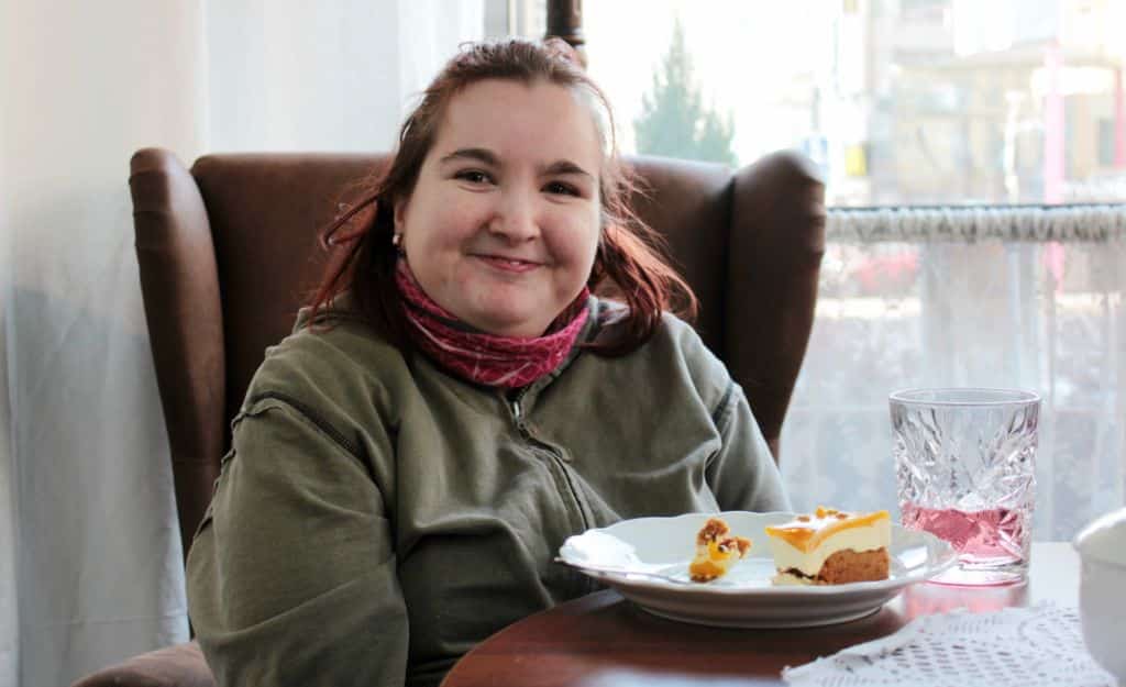 Kuvassa Niina Jäntti istuu hymyillen kahvilassa