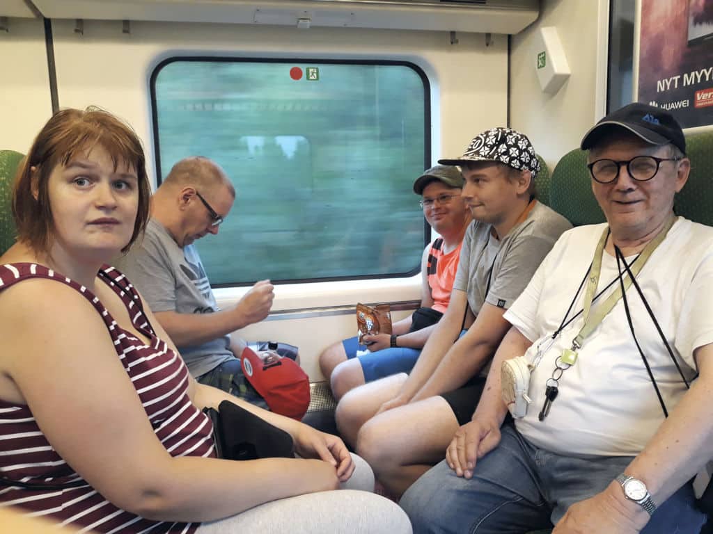 Ryhmä ihmisiä matkustaa junalla.