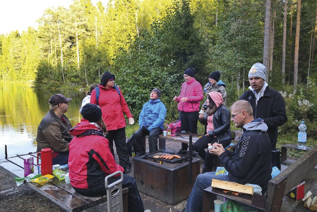 Ryhma ihmisia retkella ulkona metsassa.