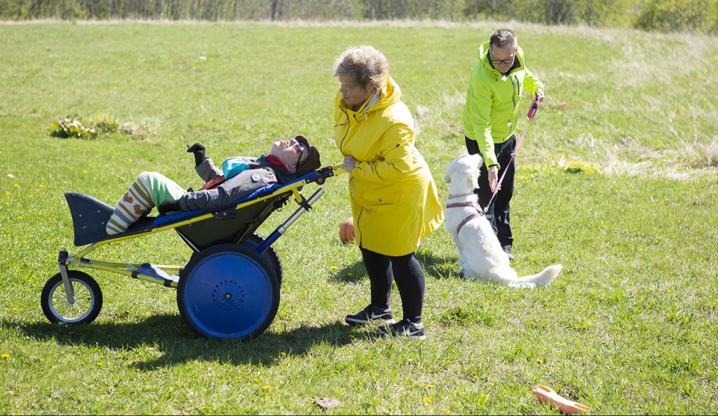 Vaikeasti vammainen Otso Nohteri nauttii ulkoilusta Kangoo-rattaissa. Mukana vanhemmat Vesa ja Sari Nohteri. Kuva: Laura Vesa