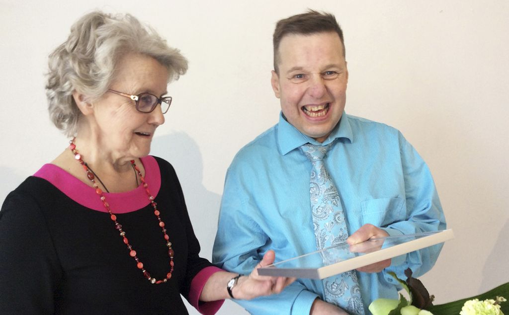 Äiti ja poika iloitsivat yhdessä, kun Pasi Soukkala oli valittu Kettukin vuoden taiteilijaksi vuonna 2016. He katsovat yhdessä kehystettyä kunniakirjaa jota Pasi pitää kädessä.