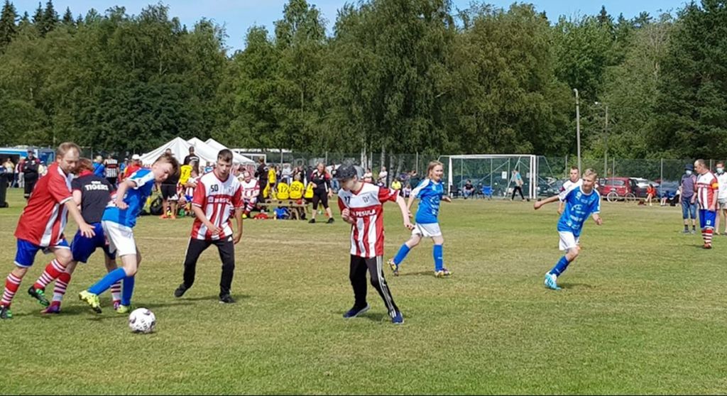 Jalkapalloilija syöttää pallon toiselle pelaajalle