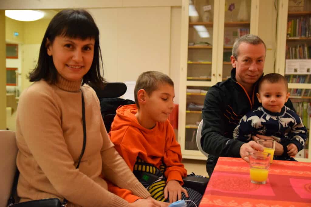 Anna Tsepkovska ja perhe istuvat yhdessä pöydän ääressä.