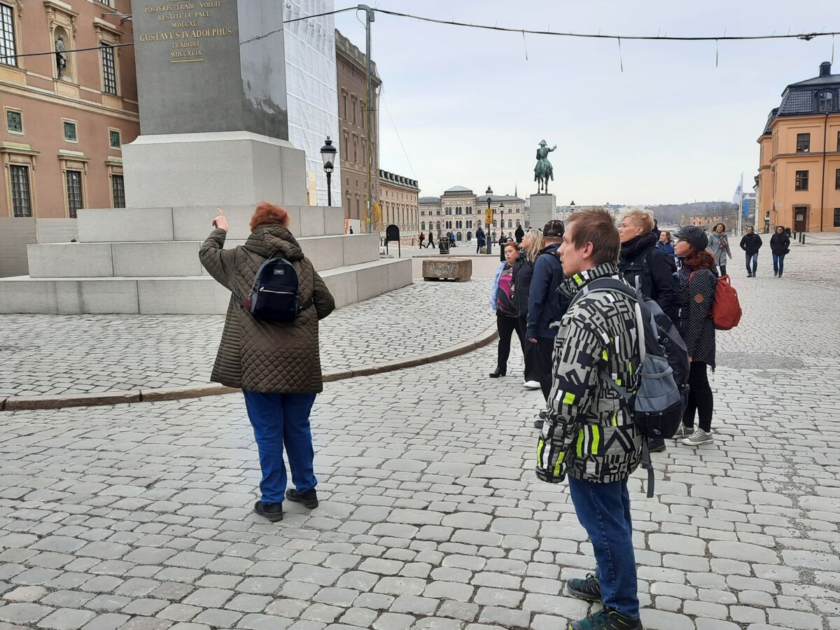 Ryhmä seisoo kuninkaanlinnan edustalla. Yksi ryhmäläinen osoittaa kuninkaanlinnaa ja muut katselevat sitä.