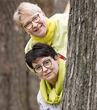 Äitikamut Tuija Laine ja Pia Ylisuvanto kurkistavat puun takaa. Kuva Laura Vesa.