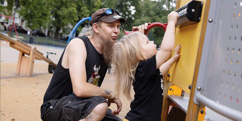 Aleksi Kirves ja hänen Otso-poikansa tutkivat yhdessä leikkivälinettä leikkipuistossa.