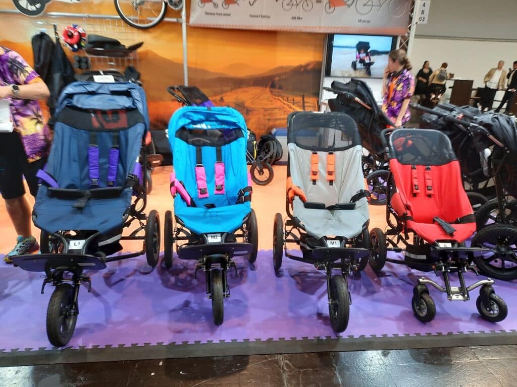 Rivissä neljä eri väristä uutta maastopyörätuolia Saksan apuvälinemessuilla kuvattuna syyskuussa 2022.