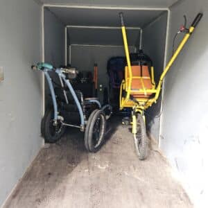 Sininen Kangoo-monitoimiratas peräkärryn oikeassa takanurkassa. Selkänoja on vasten peräkärryn takaseinää. Kangoon vieressä, peräkärryn vasemmassa takanurkassa on oranssi-musta Joelette-maastokärry selällään. Vetoaisat on taitettu kokoon kärryn sivuille. Joeletten istuinosa osoittaa koti peräkärryn oviaukkoa. Kangoon eteen työnnettynä kelta-oranssi Easytrekking-maastokärry. Kärryn etuosanojaa maahan ja takana olevat työntöaisat osoittavat yläviistoon. Kärryn etupuoli on suunnattu peräkärryn peräseinään. Sininen Hippocampe-maastopyörätuoli on Joeletten edessä vinottain niin, että eturengas työntyy keskeltä Joeletten ja Kangoon väliin kohti peräseinää.
